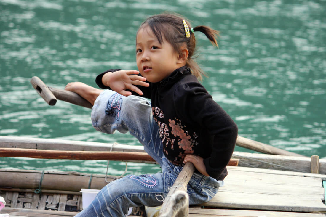 petite fille barrant une barque traditionnelle.